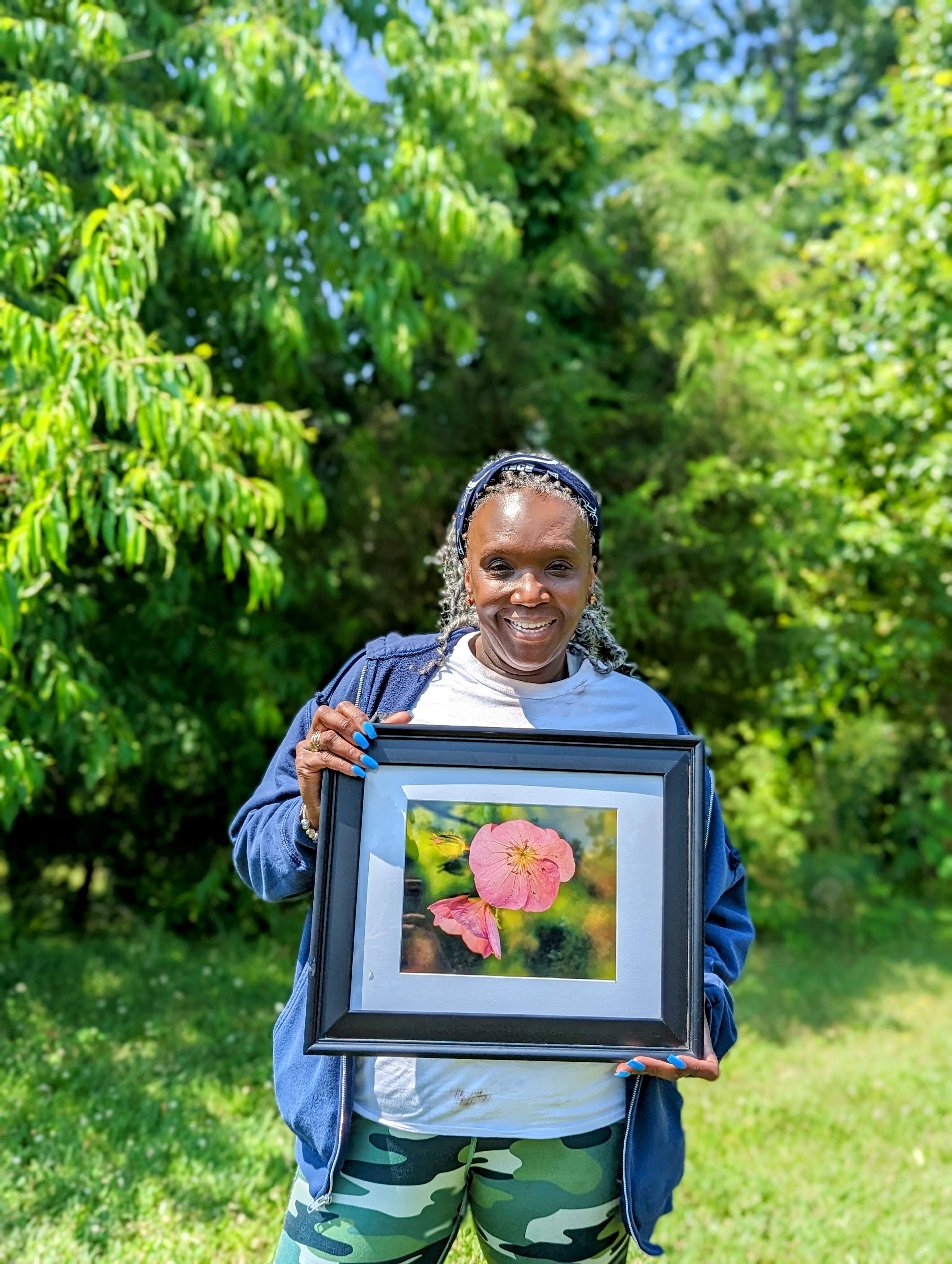 Valencia Abbot, educator, advocate, and avid hiker, holding a beautiful photo of a local wildflower